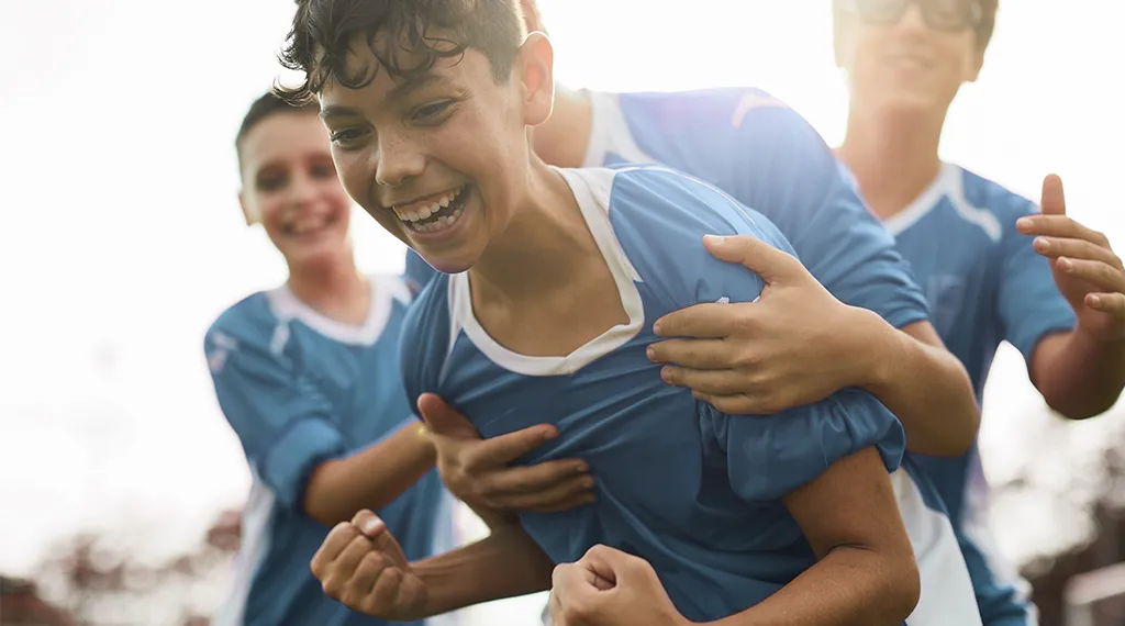 Soccer player being hugged by his teammates